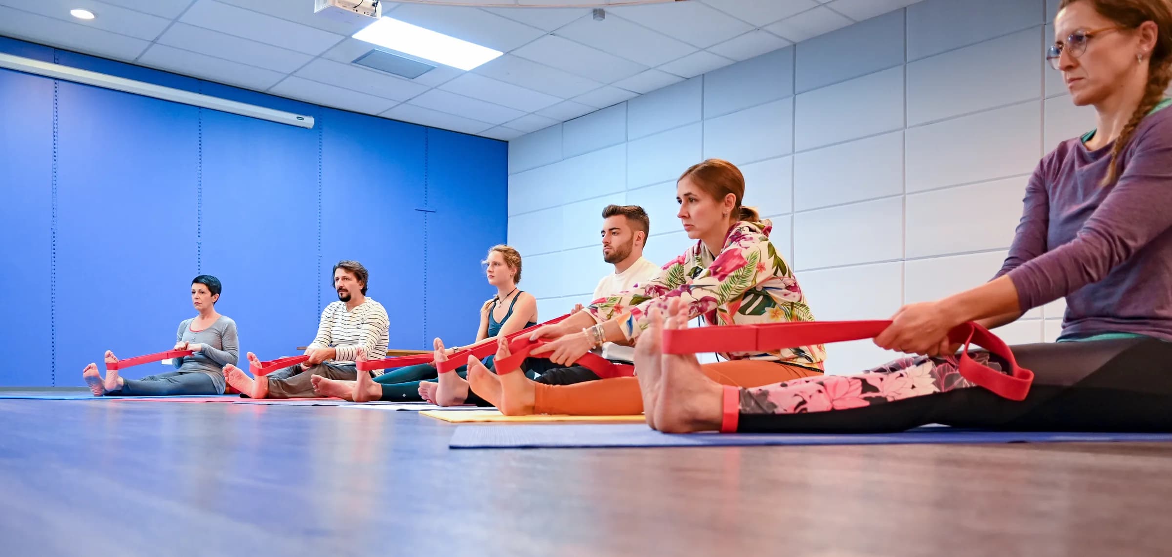 Kursgruppe übt mit Gurten im hellen Studio